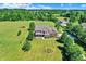Aerial view of a beautiful home with meticulously landscaped lawn, surrounded by mature trees and greenery at 13208 State Road 32 E, Noblesville, IN 46060