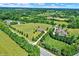 Aerial view of a property showcasing the house, surrounded by lush green fields and mature trees at 13208 State Road 32 E, Noblesville, IN 46060