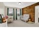 Bedroom with wood wall and crib, featuring windows, decor, and rocking chair at 13208 State Road 32 E, Noblesville, IN 46060