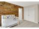 Comfortable Bedroom showcasing crib, wood wall, and view of the closet at 13208 State Road 32 E, Noblesville, IN 46060