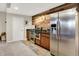 Basement kitchenette with stainless steel appliances, wooden cabinets, granite countertops, and wooden accent wall at 13208 State Road 32 E, Noblesville, IN 46060