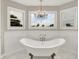 Main bathroom with a freestanding tub under a chandelier with natural lighting at 13208 State Road 32 E, Noblesville, IN 46060