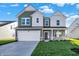 Two-story house with green and white siding, a large driveway and landscaped lawn at 573 Carroll St, New Whiteland, IN 46184