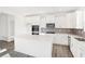 Modern kitchen with white cabinets, an island, and gray tile backsplash at 573 Carroll St, New Whiteland, IN 46184