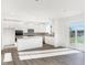 Modern kitchen with white cabinets, island, and sliding glass doors to backyard at 573 Carroll St, New Whiteland, IN 46184