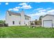 Spacious backyard featuring a fire pit area, detached garage, and lush green lawn at 1560 Cold Spring Dr, Brownsburg, IN 46112