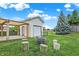 Backyard featuring a wooden pergola, detached garage, fire pit, and lush green lawn at 1560 Cold Spring Dr, Brownsburg, IN 46112