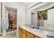 Functional bathroom with double sinks, wood cabinets, and playful shower curtain at 1560 Cold Spring Dr, Brownsburg, IN 46112