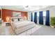 Spacious bedroom with a comfortable bed, bright accent wall, and large windows dressed with blue curtains at 1560 Cold Spring Dr, Brownsburg, IN 46112