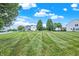 Well-kept front lawn with a view of the neighborhood homes and mature trees at 1560 Cold Spring Dr, Brownsburg, IN 46112