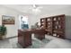 Well-appointed home office with a large wooden desk, built-in bookshelf, and ample natural light, ideal for productivity at 1560 Cold Spring Dr, Brownsburg, IN 46112
