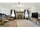 An open-concept living room with fireplace, ceiling fan, comfortable furniture, and good natural light at 1560 Cold Spring Dr, Brownsburg, IN 46112