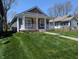 A cozy home with a bright yellow door and inviting front porch surrounded by a green lawn at 3636 Salem St, Indianapolis, IN 46208