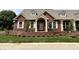 Charming brick home with dormer windows, cream trim, and manicured front yard at 7936 Beaumont Green Pl, Indianapolis, IN 46250