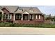 Charming brick home featuring symmetrical windows, dormers, and a quaint front porch with white columns at 7942 Beaumont Green Pl, Indianapolis, IN 46250