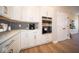 Modern kitchen with white cabinets, quartz countertops, and stainless steel appliances including double ovens at 7942 Beaumont Green Pl, Indianapolis, IN 46250