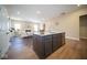 View of open-concept kitchen island with modern faucet, stainless steel dishwasher, and seamless flow into the living room at 7942 Beaumont Green Pl, Indianapolis, IN 46250