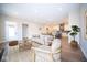 Bright living room with modern decor, hardwood floors, and an open layout leading into the dining and kitchen areas at 7942 Beaumont Green Pl, Indianapolis, IN 46250