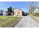 Cozy brick home featuring a spacious driveway leading to a detached garage in the backyard at 3612 Schofield Ave, Indianapolis, IN 46218
