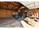 Garage interior with exposed wood ceiling, storage shelves, seating, and a workbench at 3612 Schofield Ave, Indianapolis, IN 46218