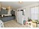 Spacious kitchen with white appliances, gray cabinets, brick walls, tile floors and natural light at 3612 Schofield Ave, Indianapolis, IN 46218
