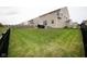 A large grassy backyard enclosed by a black metal fence and featuring an outdoor patio at 6748 Fallen Leaf Dr, Whitestown, IN 46075