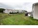 A spacious backyard with green grass, a black metal fence, and a patio with grill and furniture at 6748 Fallen Leaf Dr, Whitestown, IN 46075