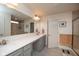Bright bathroom featuring double sinks, a large mirror, and a glass-enclosed shower at 6748 Fallen Leaf Dr, Whitestown, IN 46075