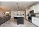 Modern kitchen with black island, granite countertops, white cabinets, and stainless-steel appliances at 6748 Fallen Leaf Dr, Whitestown, IN 46075