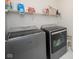 Functional laundry room featuring modern front-loading washer and dryer with storage shelving at 6748 Fallen Leaf Dr, Whitestown, IN 46075