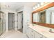 Bathroom featuring a double sink vanity, a wood-trimmed mirror, and a tiled walk-in shower at 11193 Harriston Dr, Fishers, IN 46037