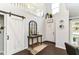 Bright foyer with dark wood floors, a sliding barn door, and a view of the open staircase at 11193 Harriston Dr, Fishers, IN 46037