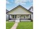 Charming bungalow with a covered front porch, black trim, and a well-maintained lawn at 906 N Parker Ave, Indianapolis, IN 46201