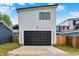 Modern garage with a sleek black door, white siding, and concrete driveway, offering ample parking space at 1218 Orange St, Indianapolis, IN 46203