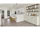 Bright kitchen boasts white cabinets, counter seating, and floating wood shelves at 1218 Orange St, Indianapolis, IN 46203