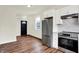 Open living space connected to the kitchen featuring wood floors, white walls, and stainless steel appliances at 1218 Orange St, Indianapolis, IN 46203