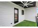 Covered patio space with artificial turf and sleek white siding with black trim and a ceiling fan at 1218 Orange St, Indianapolis, IN 46203