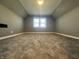 A finished attic space featuring carpeted floors and a window for natural light at 1702 Barth Ave, Indianapolis, IN 46203