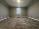 Finished attic bedroom featuring carpeted floors and a window for natural light at 1702 Barth Ave, Indianapolis, IN 46203
