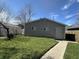 Rear view of house with a small lawn and concrete walkway leading to the back entrance at 1702 Barth Ave, Indianapolis, IN 46203