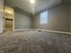This bedroom features plush carpeting, neutral walls, and a window for natural light at 1702 Barth Ave, Indianapolis, IN 46203