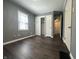 This bedroom features woodgrain floors, gray walls, white doors, and plenty of natural light at 1702 Barth Ave, Indianapolis, IN 46203