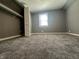 Carpeted bedroom has gray walls, window with natural light, and closet with bifold doors at 1702 Barth Ave, Indianapolis, IN 46203