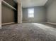 Carpeted bedroom has gray walls, window with natural light, and closet with bifold doors at 1702 Barth Ave, Indianapolis, IN 46203