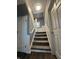 Carpeted staircase with white painted railings and doors lead to the upper level at 1702 Barth Ave, Indianapolis, IN 46203