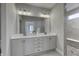 Modern bathroom with double vanity, a large mirror, stylish lighting, and a glass-enclosed shower at 11451 Neptune Dr, Fishers, IN 46040