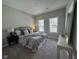 This bedroom features soft gray tones, a comfortable upholstered bed, and ample natural light from two windows at 11451 Neptune Dr, Fishers, IN 46040