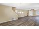 Bright living room with wood-look flooring, chandelier, and access to staircase and front door at 1024 Rotherham Ln, Beech Grove, IN 46107