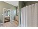 Neutral bathroom with a patterned shower curtain and view into the main bedroom at 9083 W Koger Ln, Martinsville, IN 46151