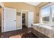 Bright bedroom with a large window, open closet and wood floors with tan walls at 9083 W Koger Ln, Martinsville, IN 46151